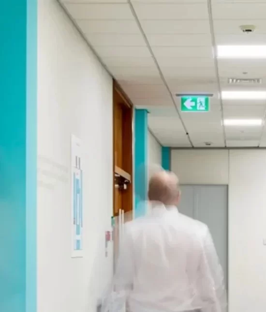 Person walks down hallway featuring an emergency drop down light