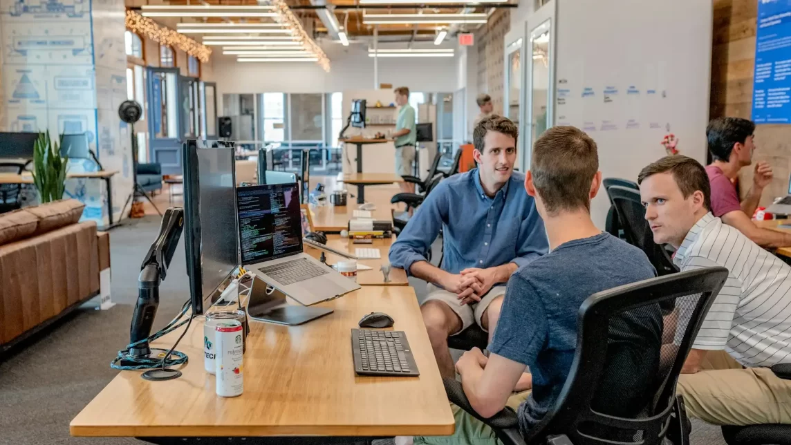 An office space with three men having a conversation